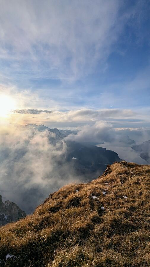 Sunrise on a grassy summit ridge above a sea of clouds